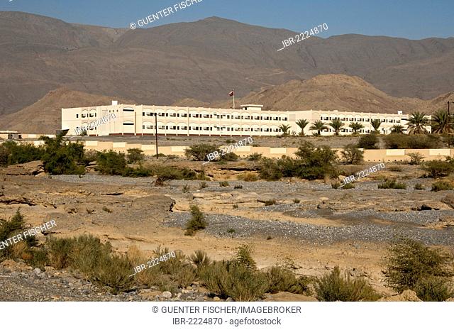 Modern school buildings in the barren landscape at the foot of the Hajar Mountains on the outskirts of Nizwa, Sultanate of Oman, Middle East, Asia