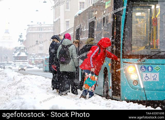 RUSSIA, ST PETERSBURG - NOVEMBER 28, 2023: People get on a bus during a snowfall. Valentin Yegorshin/TASS