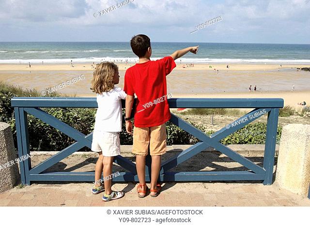 Boy and girl looking at the sea, Lacanau-Océan. Gironde, Aquitaine, France