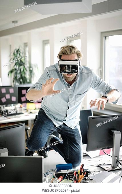 Businessman wearing VR glasses in office pretending to be a lion