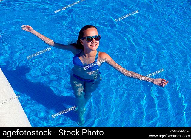 beautiful teen age girl swimming in outdoor swimming pool. outdoor shot. copy space