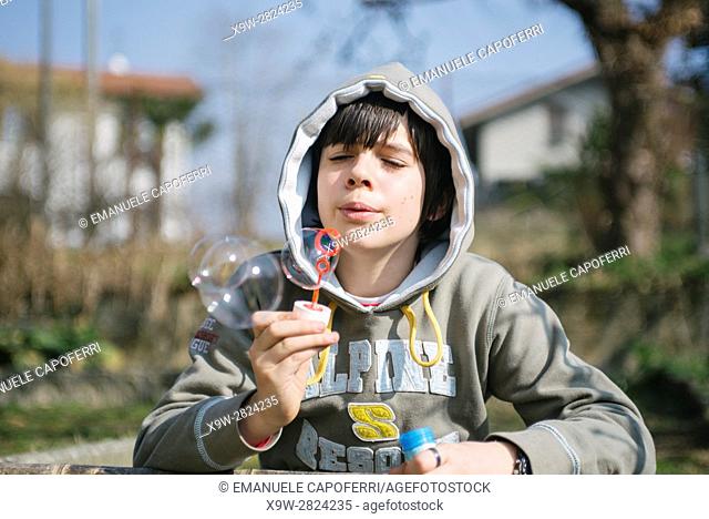 boy makes soap bubbles, malgesso.italy