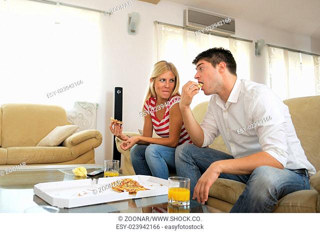 couple at home eating pizza
