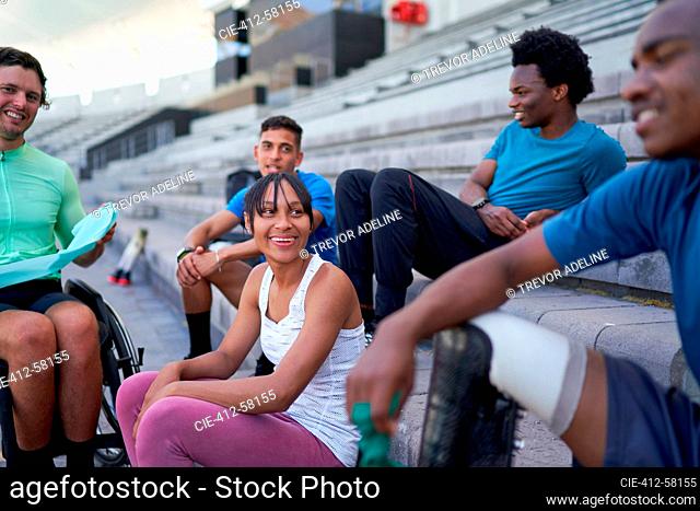 Happy young athlete friends in bleachers