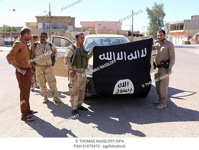 Kurdish fighters pose with a taken flag of Islamic State (IS) Makmur Front, Iraq, 12 September 2014. Photo: Thomas Rassloff/dpa | usage worldwide