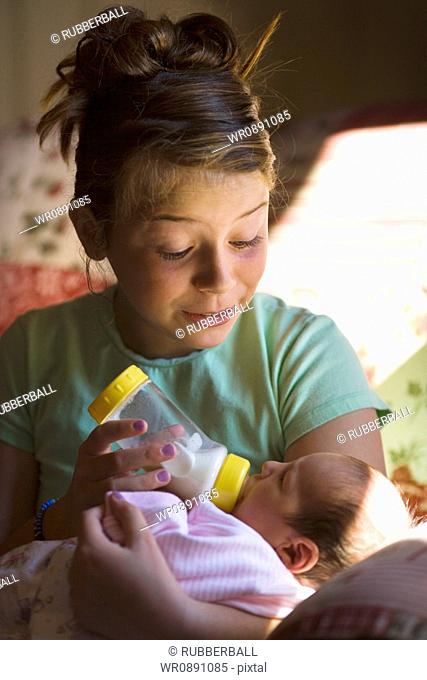 Mother feeding her baby girl a bottle of milk
