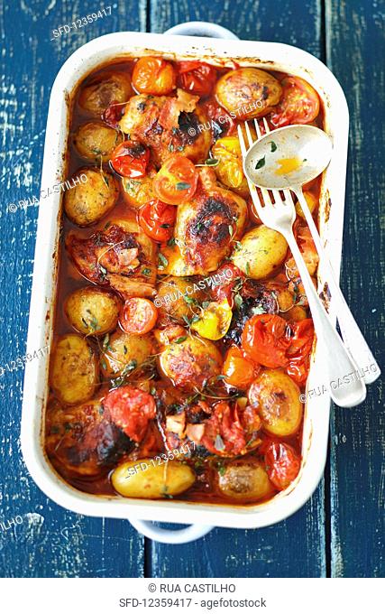 Chicken thights baked with potatoes, tomatoes and thyme
