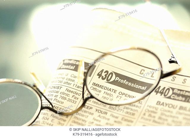 Glasses laying on classified ads