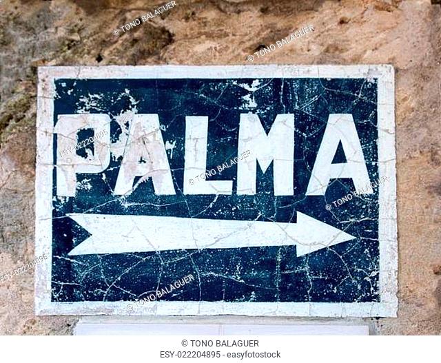 Aged blue road sign with arrow to Palma de Majorca