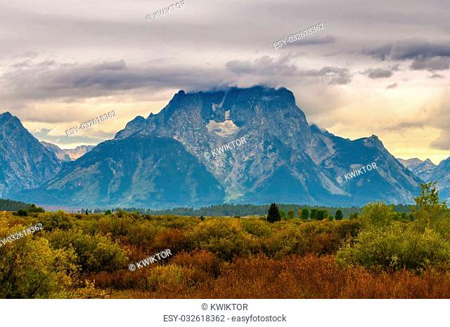 Beautiful fall colors and dramatic sky over Grand Teton Mountains - Willow Flats