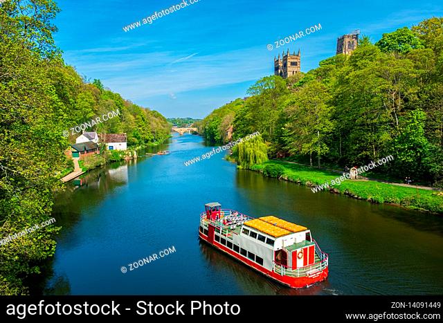 Durham, United Kingdom - April 30, 2019: A cruise boat cruises along River Wear on a beautiful spring day in Durham, United Kingdom