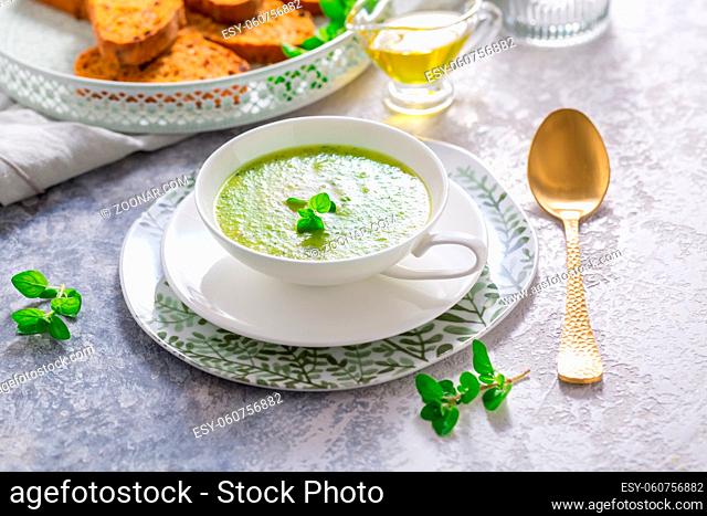Homemade zucchini soup with tomato ciabatta bread and herbs