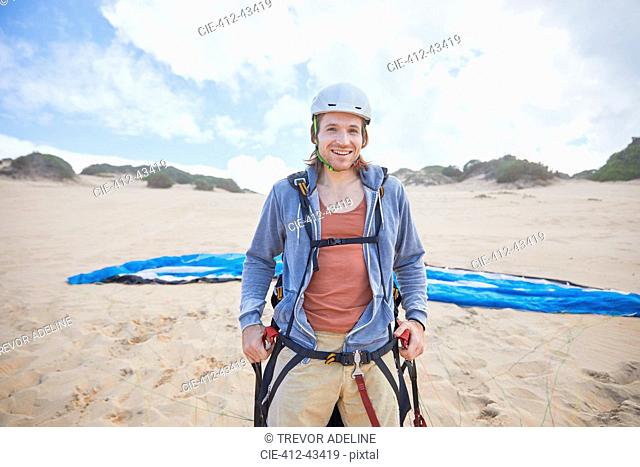 Portrait confident male paraglider on beach