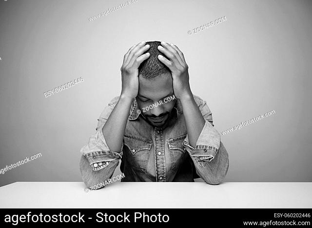 Portrait of depressed bearded black man over light background. Black and white. High quality photo