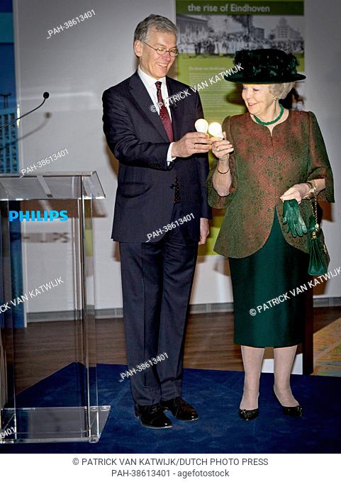 Dutch Queen Beatrix and CEO of Philips Electronics, Frans van Houten, hold glowing light bulbs at the opening act for the new Philips Museum in Eindhoven