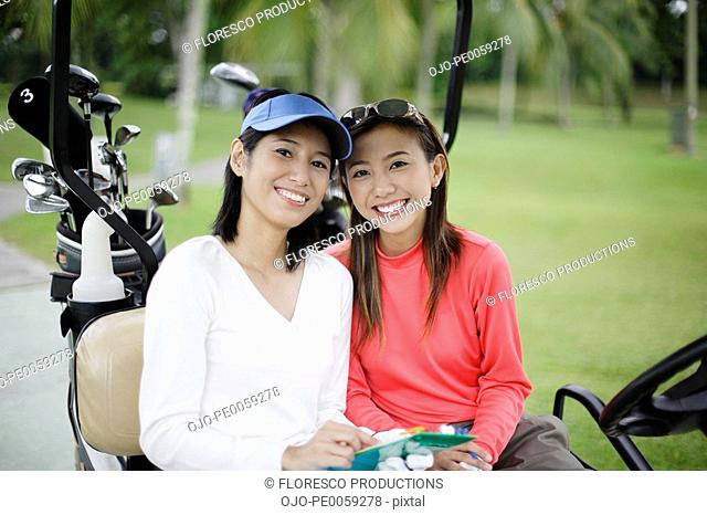 Two women in a golf cart