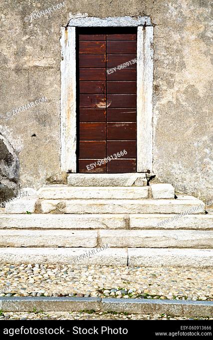 abstract cross  brass brown knocker in a  closed wood door  varese italy azzate sumirago sunny da