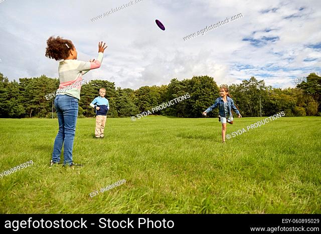 happy children playing with flying disc at park