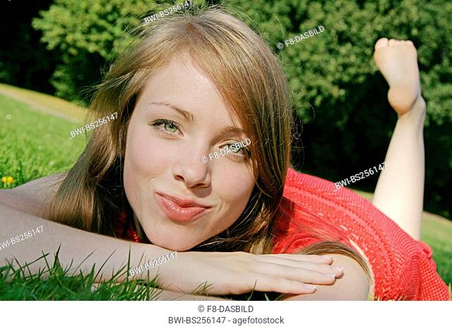 young woman lying in meadow, Germany