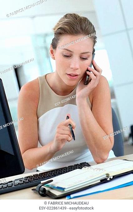 Businesswoman at her desk booking meeting hours on agenda