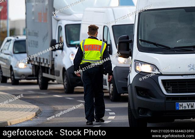 20 October 2021, Brandenburg, Frankfurt (Oder): A police officer stops vehicles on the border bridge between Germany and Poland to check for illegal entrants
