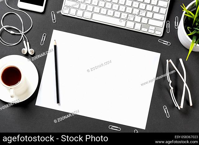 Top view of modern workplace with blank paper sheet. Flat lay black surface with smartphone, notepad and cup of coffee. Top view office workspace and freelance
