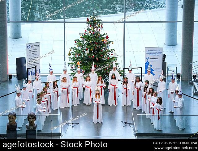 15 December 2023, Berlin: The Lucia Choir from the Stockholm Music High School sings Swedish and German Christmas carols on the Spree side of the Paul Löbe...