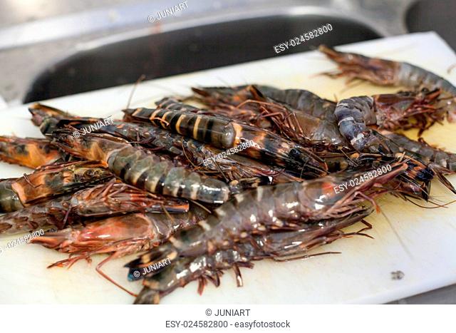 Fresh tiger prawns waiting on a plate in a kitchen to be cooked in a delicious gourmet seafood meal