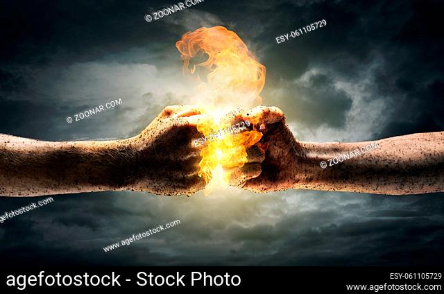Close up of two fists hitting each other over dramatic sky background