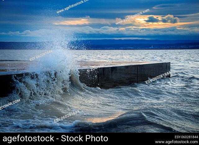 Crashing wave on the pier of Illmitz on Lake Neusiedlersee in Burgenland Austria