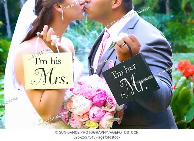 bride & groom kissing & holding 'Mrs. & Mr.' signs