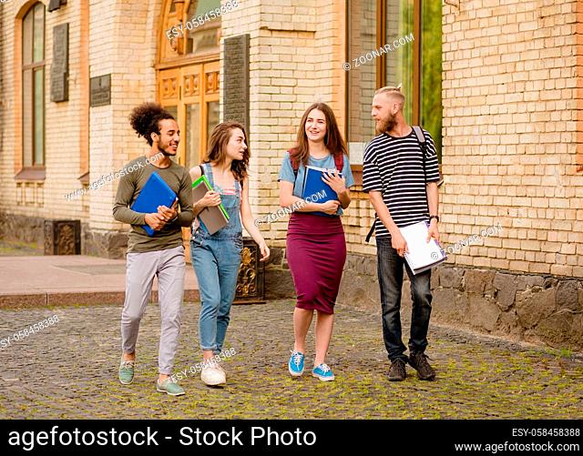 College students walking in campus. Happy multiethnic friends going for a walk after lectures