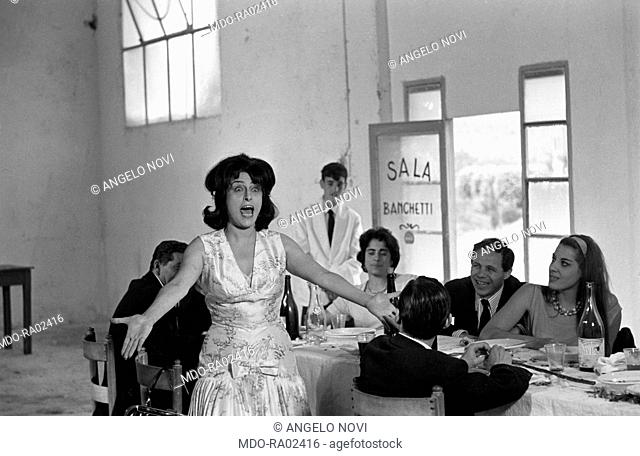 Italian actress Anna Magnani singing at a wedding lunch in the film Mamma Roma. Rome, 1962