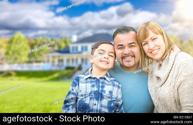 mixed-race family in front yard of beautiful house and property