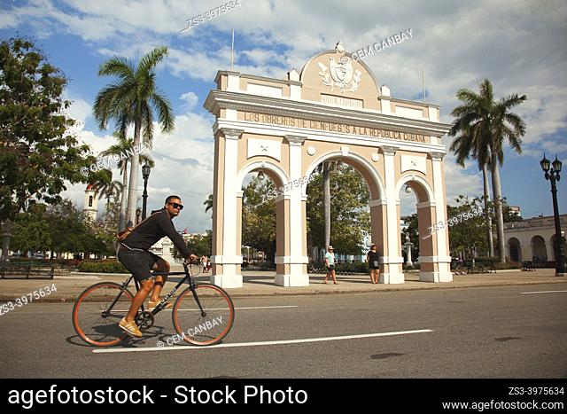 Cyclist in front of the Arch Of Triumph-Arco del Triunfo near Parque Jose Marti at the historic center, Cienfuegos, Cienfuegos Province, Cuba, West Indies