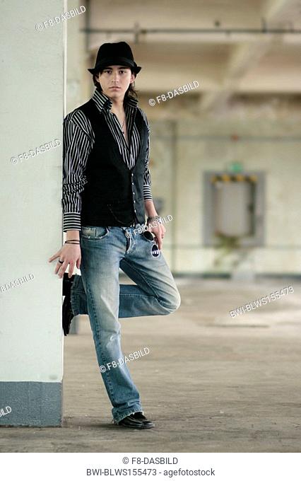young man leaning thoughtfulness against a column, Germany