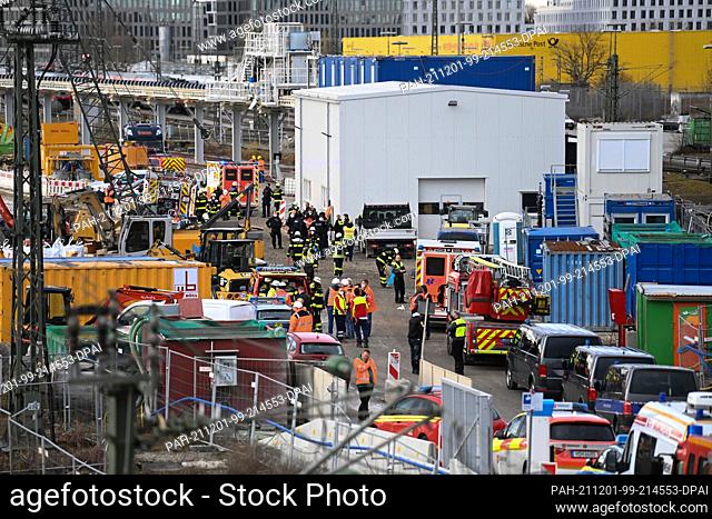 01 December 2021, Bavaria, Munich: Firefighters, police officers and railway employees stand on a railway site at the Donnersbergerbrücke
