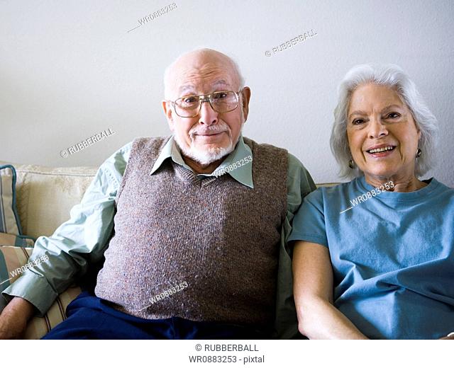 Portrait of a senior couple sitting on a couch and smiling