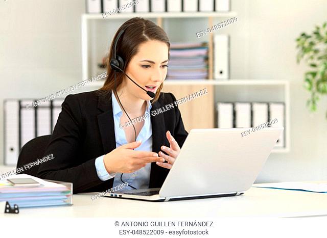 Telemarketer talking on-line having a video call with a laptop at office