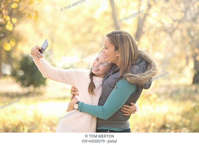 Mother and daughter taking selfie outdoors