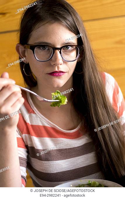 Portrait of a 26 year old woman eating in a restaurant