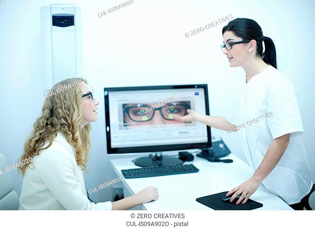 Optician guiding patient on choice of eyeglasses