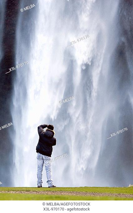Photographer in Seljalandsfoss waterfall  Iceland