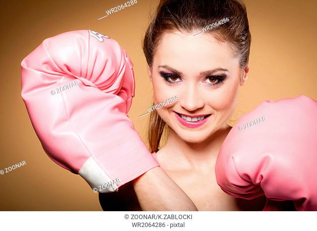Female boxer wearing big fun pink gloves playing sports