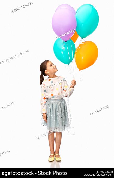 happy girl in birthday party hat with balloons
