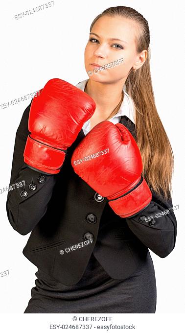 Businesswoman wearing boxing gloves standing in boxing stance, giving tough look at camera. Isolated over white background