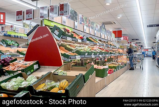 10 October 2023, Hamburg: A customer looks at the range of vegetables and fruit on offer in a LIDL store, which is usually located directly at the entrance