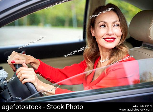 Portrait of smiling mature woman driving car