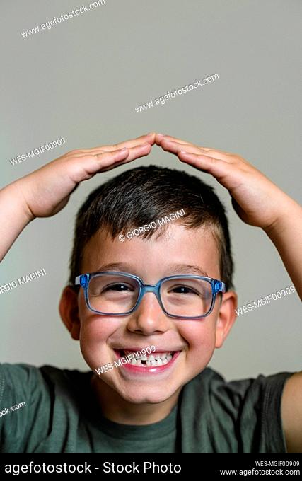 Portrait of little boy with tooth gap wearing blue glasses