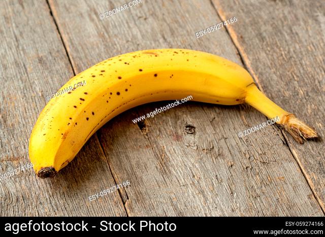 Sweet banana lying on old wooden background